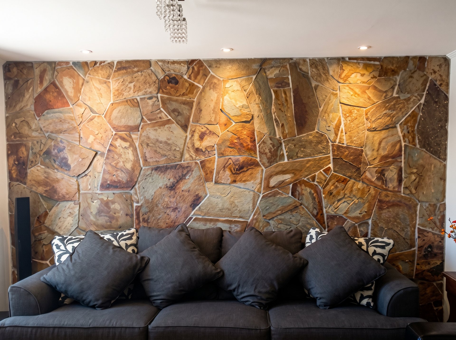 Sala con muro de piedra natural y sofás